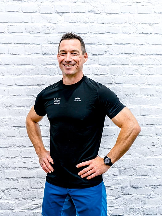 Der Personal Trainer Thorsten Völler aus Düren steht vor einer weißen Mauer